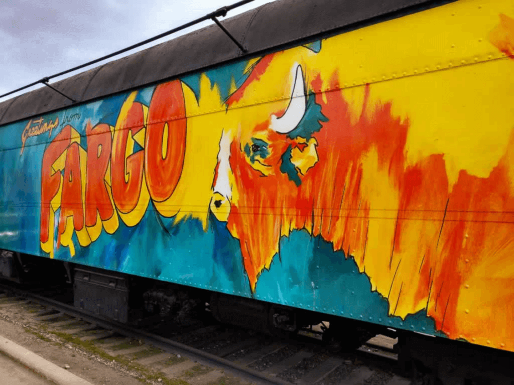 train care: A colorful train car with a buffalo painted on it.